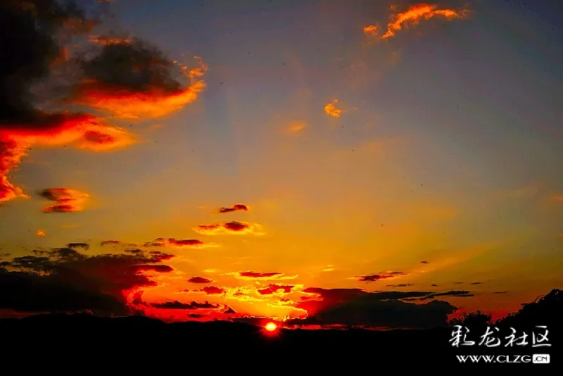 夕阳余辉便透过朵朵云层,像万道金光,如霞光万丈,把天空白云染得