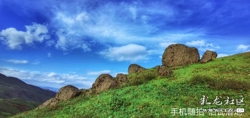 盛夏季节草场绿油油的小草和美丽的小花,有无数奇特的巨石横纵,神态各
