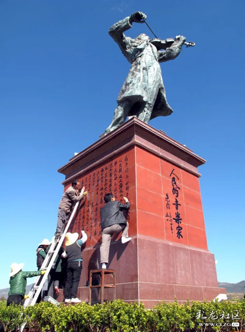玉溪聂耳文化广场的聂耳雕像基座前几名工作人员正在凭借梯子,凳子